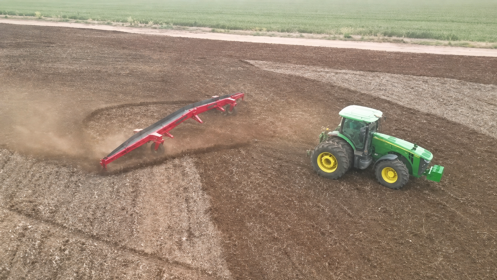 Trator trabalhando com implemento Tratormat no campo